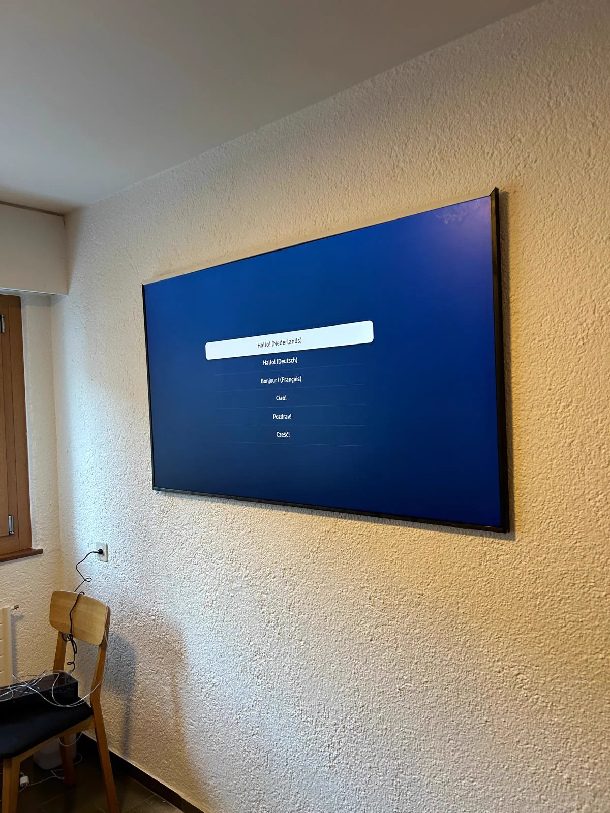 Téléviseur grand format fixé au mur d'un séjour à Sion.